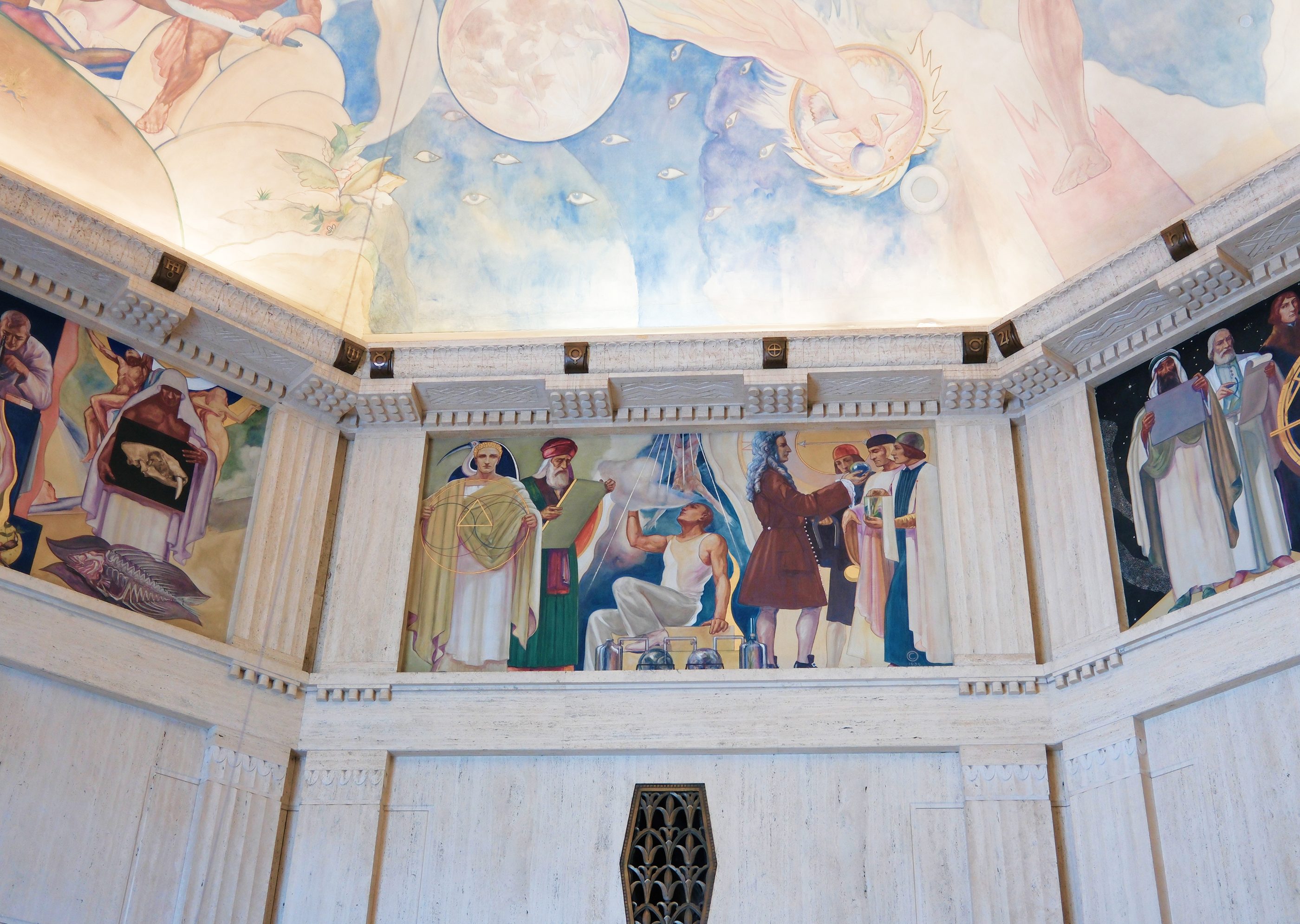 A painted mural wrapping the upper walls and ceiling of an ornate rotunda.